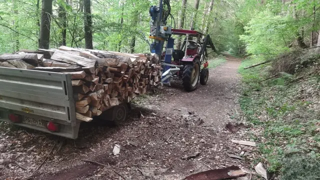 Beladener Anhänger und Traktor auf dem Weg zum Holzplatz